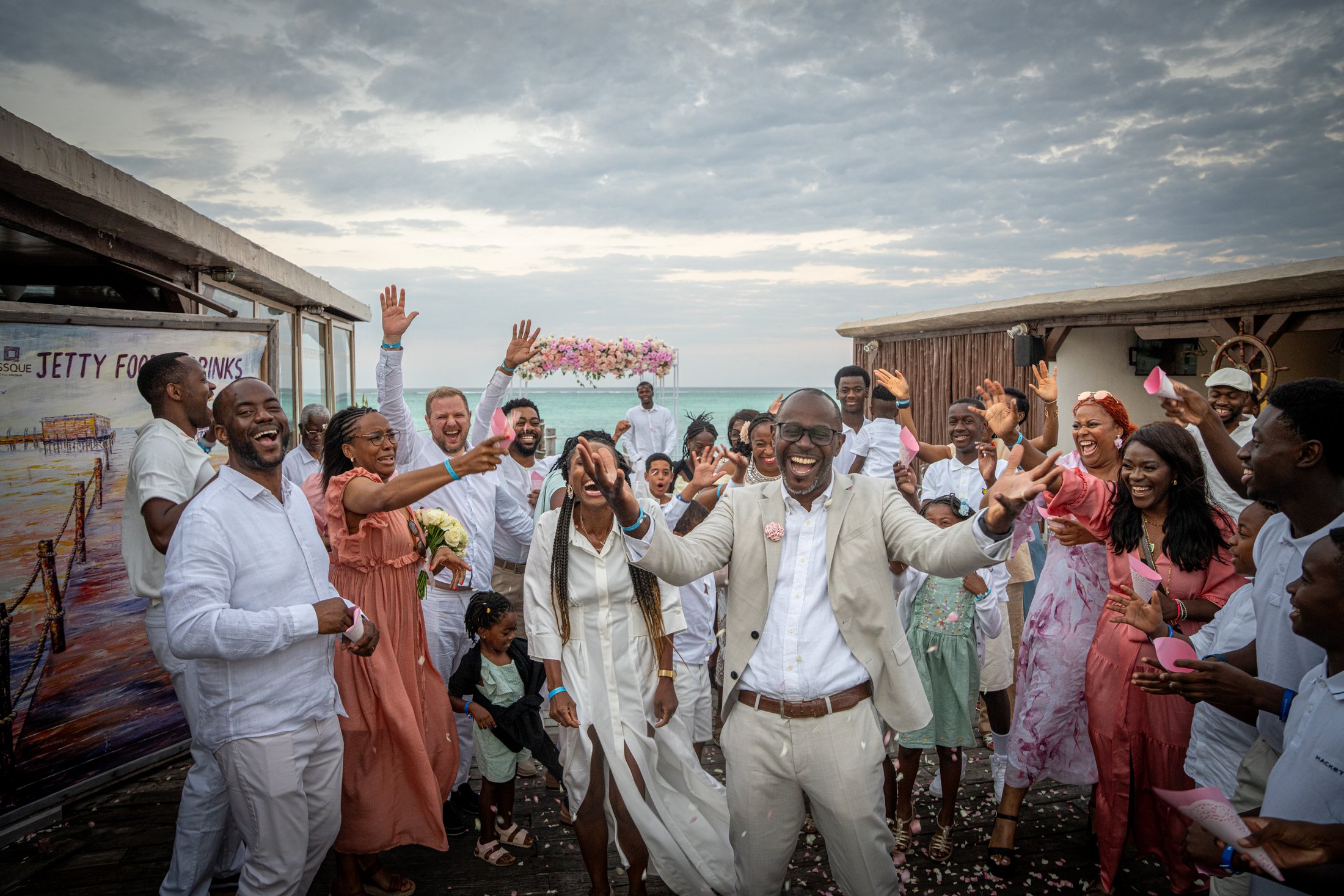 A wedding party celebrating beneath a dramatic island sky