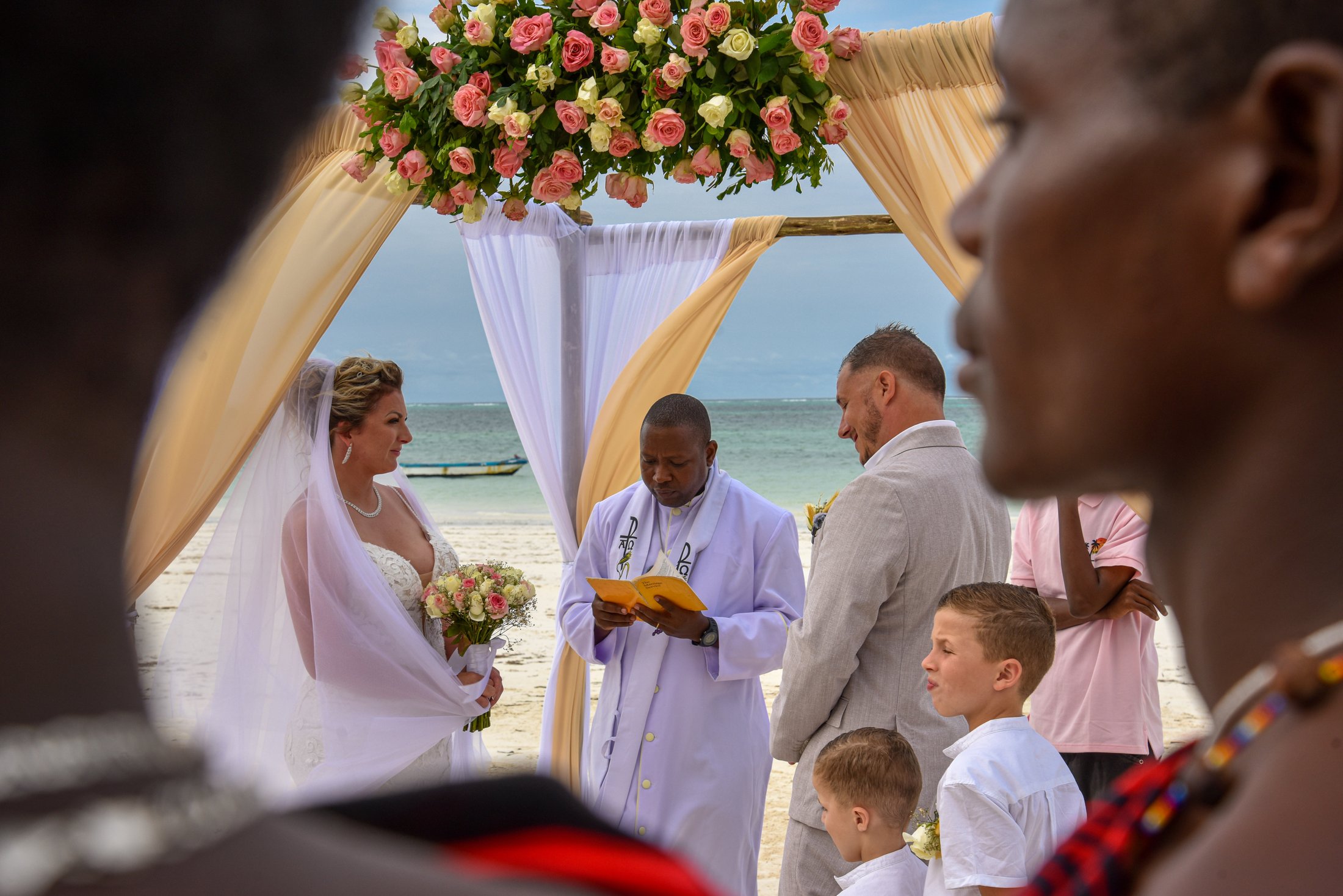 A wedding ceremony beneath a floral canopy