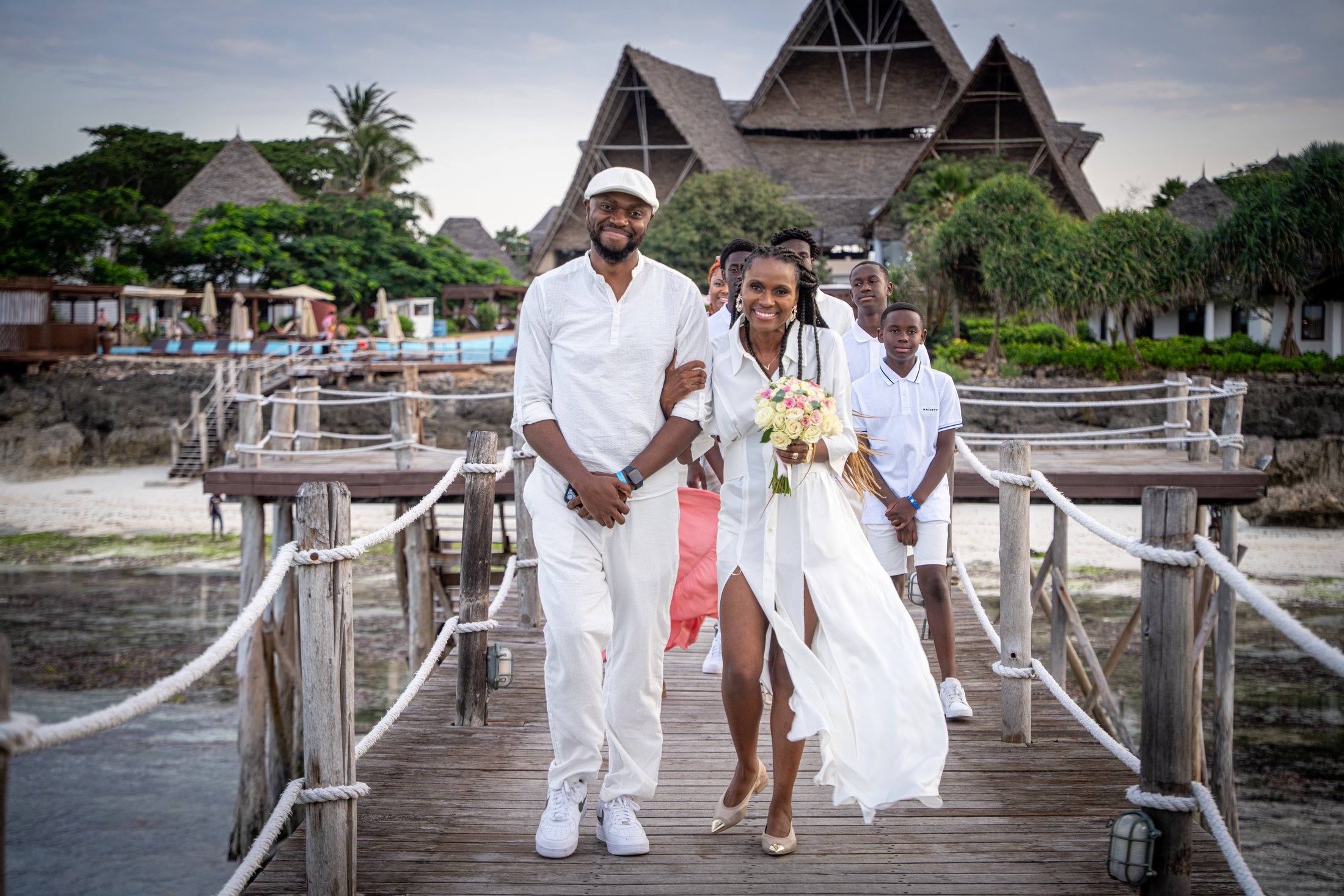 Newlyweds walking with friends along a waterfront pier